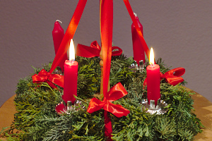 ein Adventskranz mit vier brennenden Kerzen